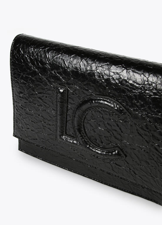 Bandolera Lola Casademunt con solapa efecto piel brillante con logo en relieve Negro