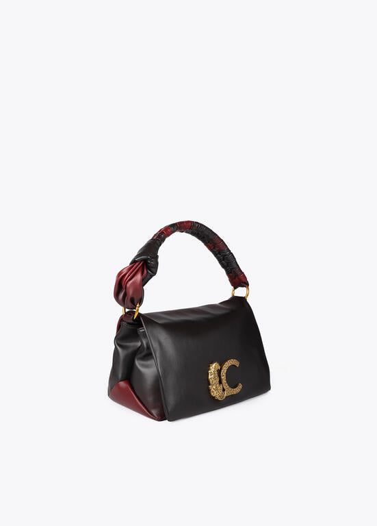 Bandolera Lola Casademunt  con solapa y nudo en asa. Logo LC leopardo negro-rojo