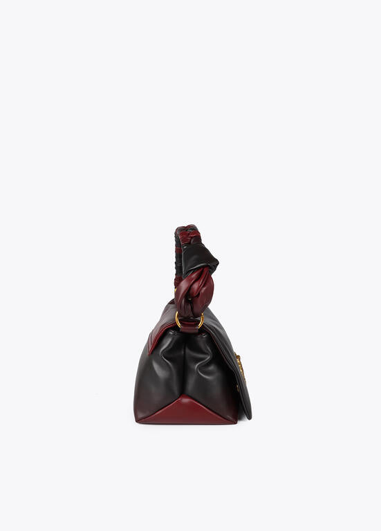 Bandolera Lola Casademunt  con solapa y nudo en asa. Logo LC leopardo negro-rojo