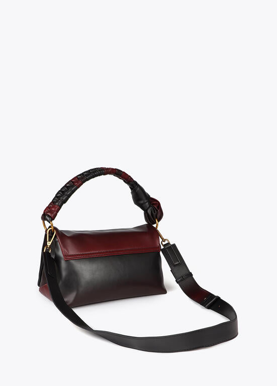Bandolera Lola Casademunt  con solapa y nudo en asa. Logo LC leopardo negro-rojo