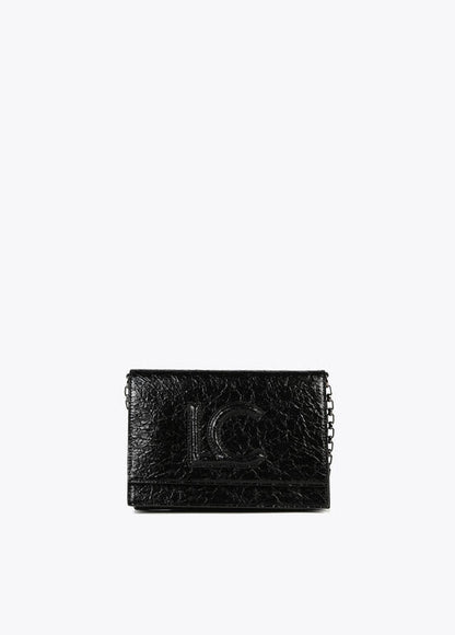 Bandolera Lola Casademunt  con solapa efecto piel brillante con logo en relieve Negro