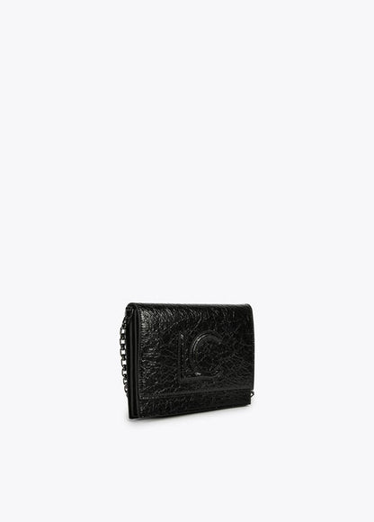 Bandolera Lola Casademunt  con solapa efecto piel brillante con logo en relieve Negro